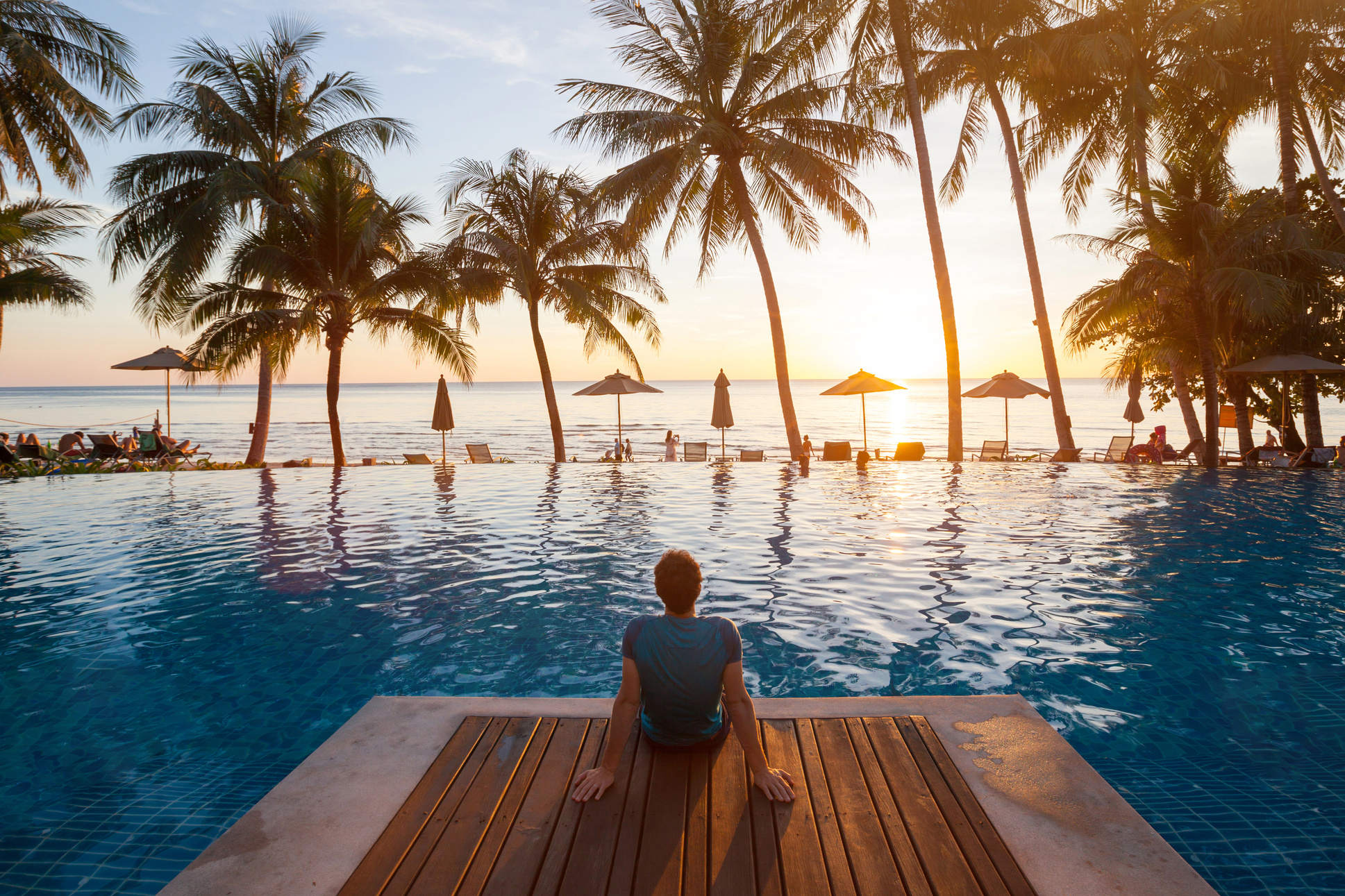 summer holiday getaway in luxury beach hotel, tourist relaxing near luxurious swimming pool